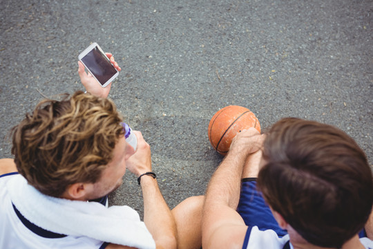 篮球运动员向朋友展示手机