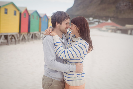 在海滩上拥抱的年轻夫妇