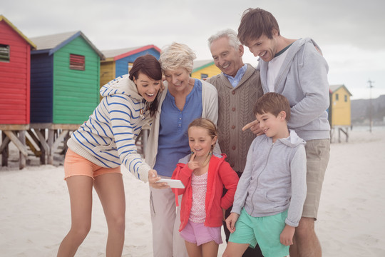 快乐的多代家庭在海滩自拍