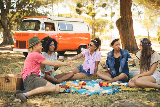 朋友们坐在野营车旁享受野餐