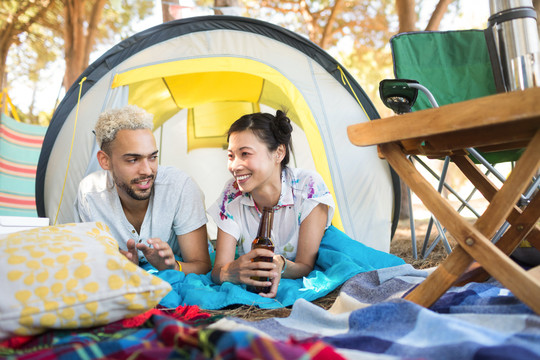 一对夫妇在露营地帐篷喝着饮料