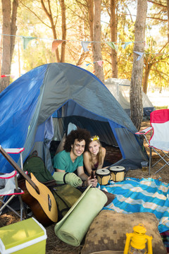 营地帐篷里微笑的年轻夫妇的画像
