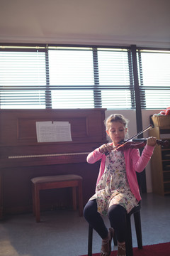 音乐课排练小提琴的女学生