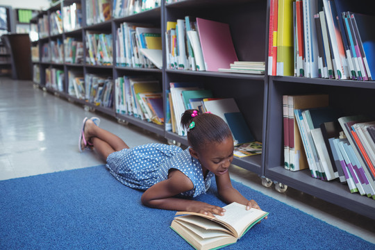 女孩躺在图书馆书架上看书