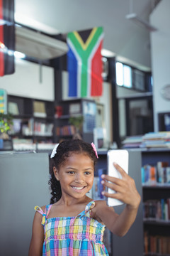 微笑的女孩站在图书馆自拍