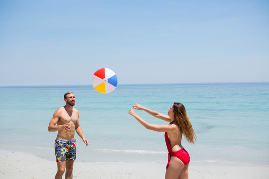 一对夫妇在沙滩上玩沙滩球
