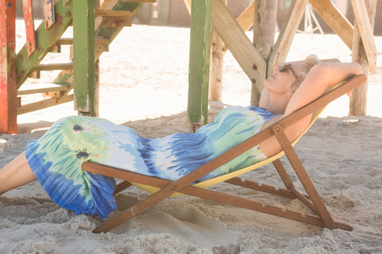 在海滩的椅子上放松的老妇人