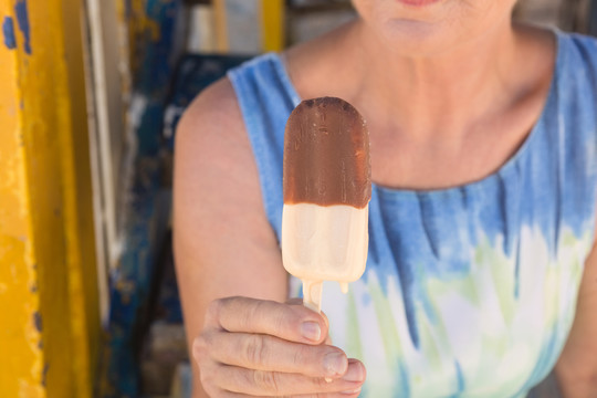 坐在沙滩小屋吃冰淇淋的女人