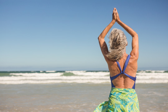 站在海滩上练习瑜伽的女人