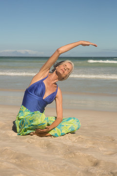 坐在沙滩上练习瑜伽的女性