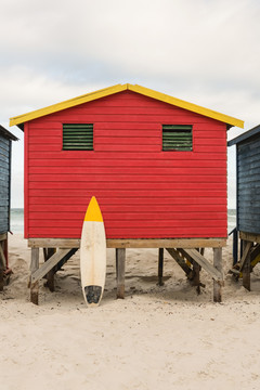 沙滩上的红色木屋旁的冲浪板
