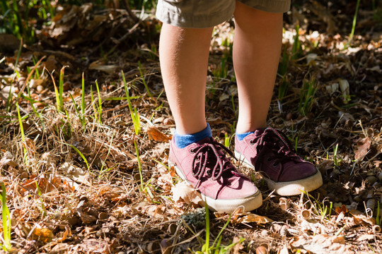 森林里穿着鞋子的男孩的特写镜头