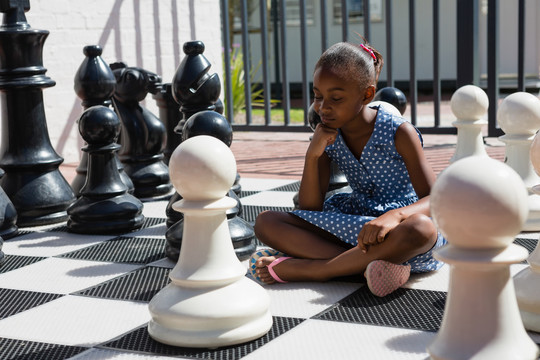 坐在棋子旁的体贴女孩