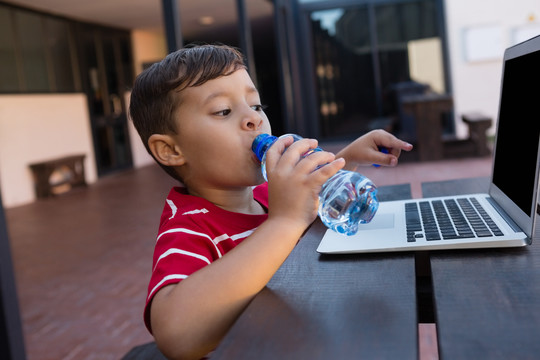 男孩在学校喝水的肖像