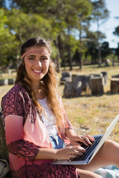 公园里使用笔记本电脑的年轻女子