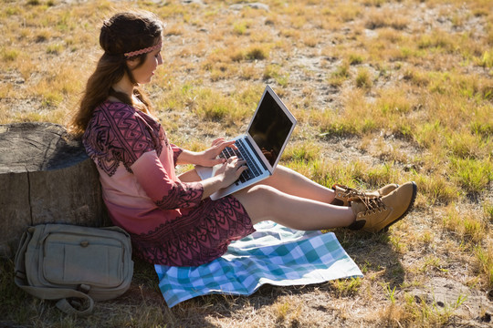 在公园里用笔记本电脑的年轻女人