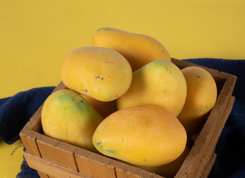 竹桶中装满黄色的美味芒果