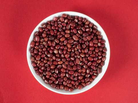 红色背景里的瓷盘上的红豆