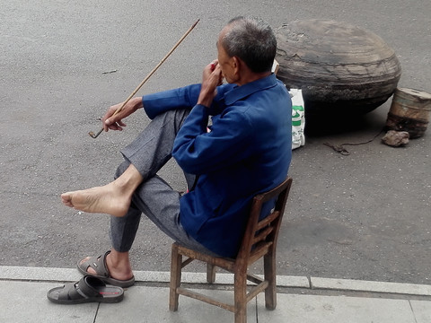 坐着用长烟斗抽烟的老人