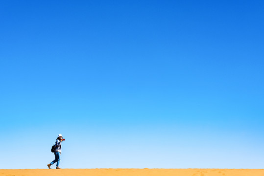 行走在沙漠沙山上的人