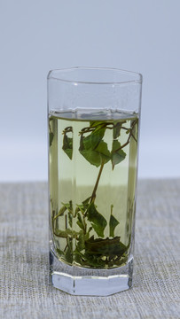 透明玻璃杯里泡开的绿色茶叶
