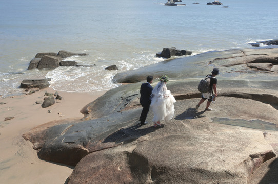 海滩拍摄婚纱照的人