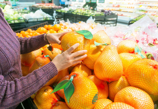 超级市场妇女在买新鲜水果