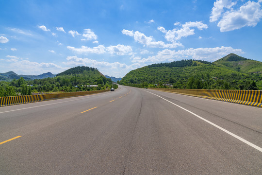 山区沥青公路在蓝天白云下的风景