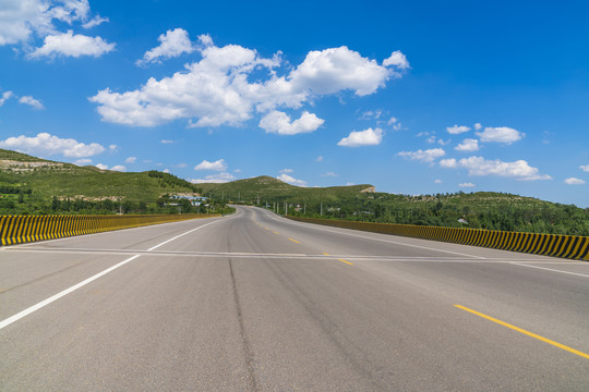 山区沥青公路在蓝天白云下的风景