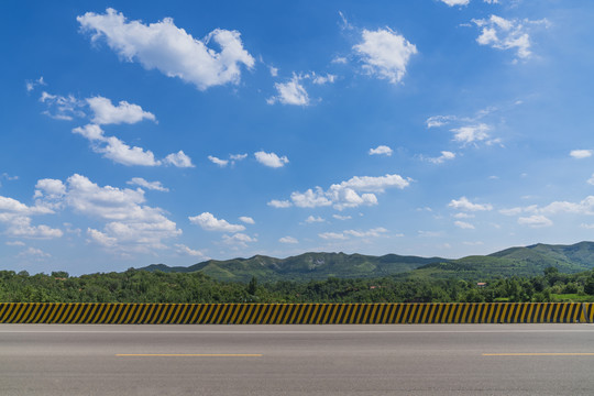 山区沥青公路在蓝天白云下的风景
