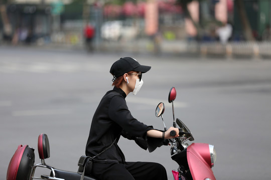 骑电动车的年轻女性