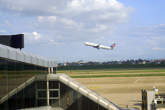 杭州萧山机场登机桥及起飞的客机