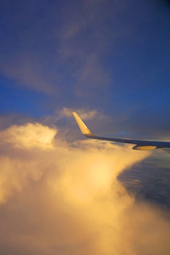 航拍金色云层中的民航客机机翼