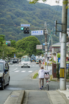 日本街道老人背影推自行车