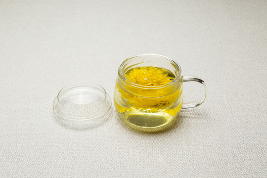 透明玻璃自饮杯里的黄色菊花茶