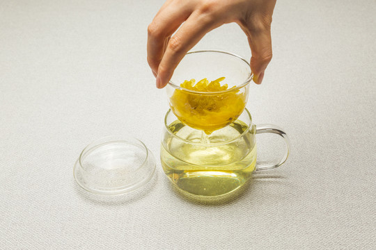 透明玻璃自饮杯里的黄色菊花茶