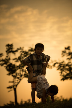 夕阳下小男孩小女孩在玩耍