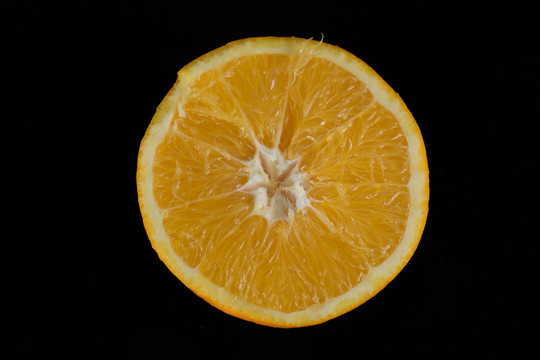 一半橙子从黑色背景隔离出来