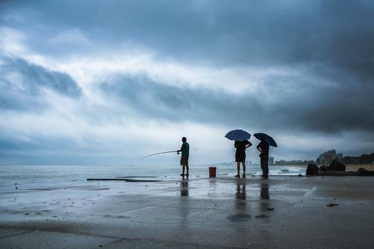 下雨天海边的钓鱼人