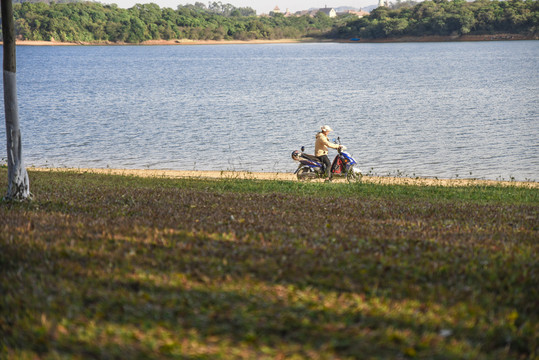 湖边骑摩托车的人