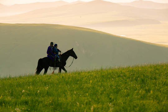 丘陵草原骑马的蒙古族