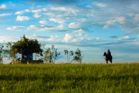 草原敖包骑马的蒙古人