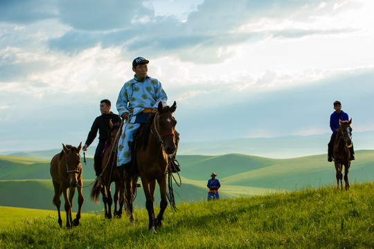 丘陵草原骑马的蒙古族男人