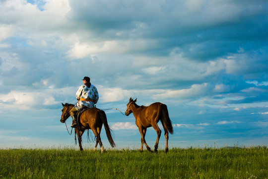 天边草原骑马的蒙古族