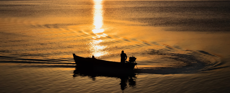 夕阳中的小船与船夫