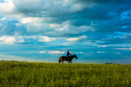 清晨草原骑马的蒙古族少年