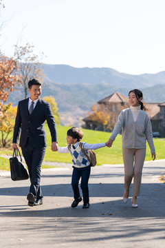 年轻夫妻送孩子去上学