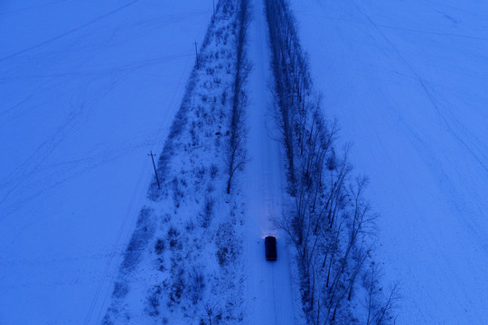 越野车在雪原夜路上行驶