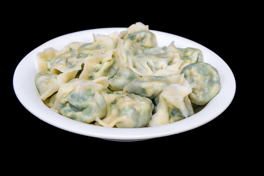 黑背景白色盘子中煮熟的水饺
