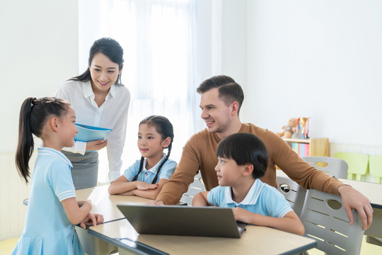 老师在课堂上辅导小学生用电脑